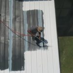 屋根塗装を行う作業員