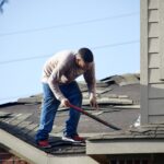 屋根の葺き替え工事をする人