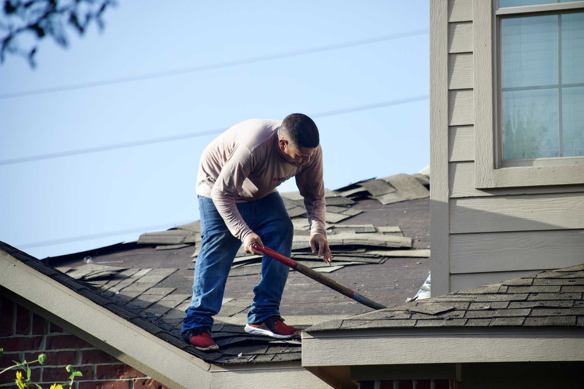 屋根の葺き替え工事をする人