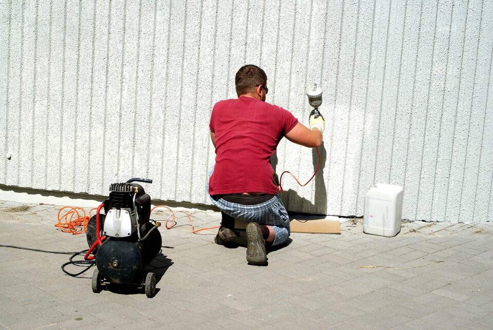 中古住宅のリノベーションで外壁を塗る人